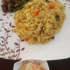 A picture of Curried rice, shredded beef and green pepper with coleslaw.