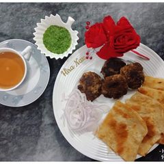 A picture of Kachay Qeemay ke kabab With Paratha, Green Chutney and Doodh-Patti Chai.