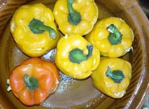 Una foto de Pimientos morrón rellenos de bistec, longaniza, pollo y queso