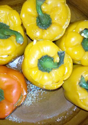 Una foto de Pimientos morrón rellenos de bistec, longaniza, pollo y queso