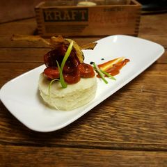 Sausages in tomato reduction w/ white potato mousseline and chip A picture of Sausages in tomato reduction w/ white potato mousseline and chip.