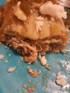 A picture of Green chili chicken tamale with queso fresco chili verde salsa.