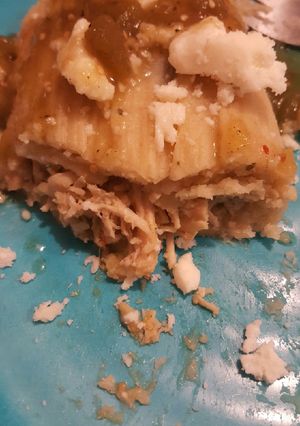 A picture of Green chili chicken tamale with queso fresco chili verde salsa.
