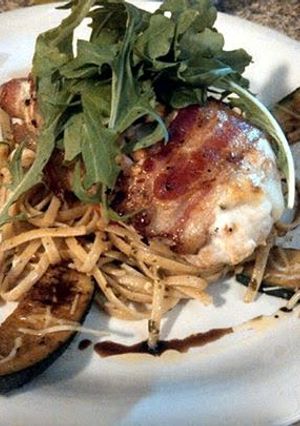 A picture of bacon wrapped stuffed chicken.