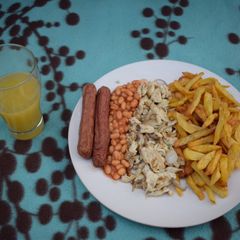 A picture of Chips, scrambled eggs and Fresh orange juice.