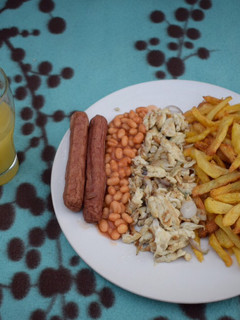A picture of Chips, scrambled eggs and Fresh orange juice.