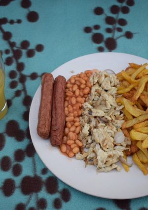 A picture of Chips, scrambled eggs and Fresh orange juice.