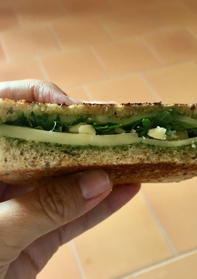 Una foto de Sandwich tostado de queso y pesto