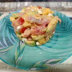 Una foto de Timbal de aguacate, mango, tomate y salmón