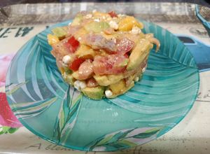 Una foto de Timbal de aguacate, mango, tomate y salmón