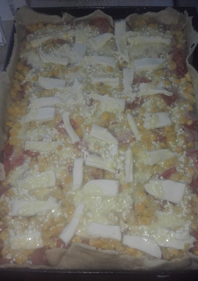 Una foto de Tarta de salchichas, tomate, choclo y queso