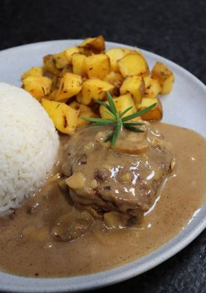 Una foto de Lomo de Cerdo con Salsa de Champiñones, Arroz Verde y Ensalada Rusa