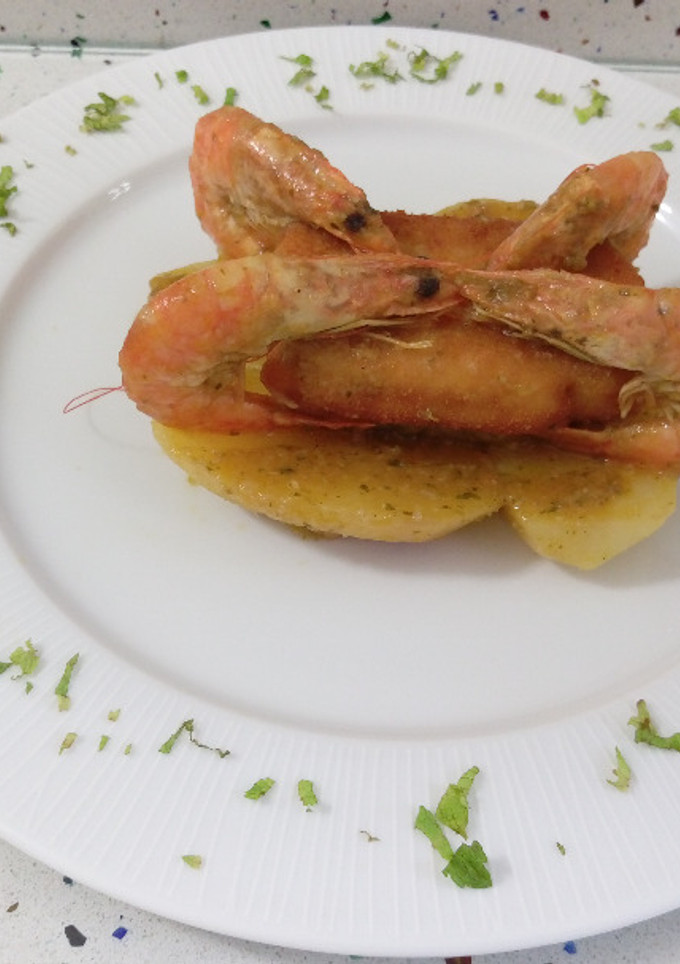 Una foto de Merluza rebozada y patatas salteadas con langostinos