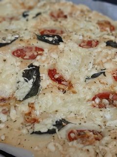 Una foto de Focaccia con tomates cherry, queso de cabra y albahaca fresca
