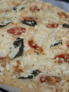 Una foto de Focaccia con tomates cherry, queso de cabra y albahaca fresca