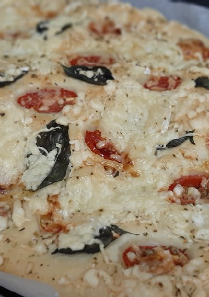 Una foto de Focaccia con tomates cherry, queso de cabra y albahaca fresca
