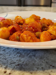 Una foto de Ñoquis con pollo y salsa de tomate