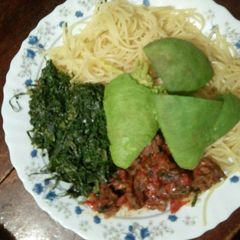A picture of Spaghetti with meat stew and sukuma wiki.