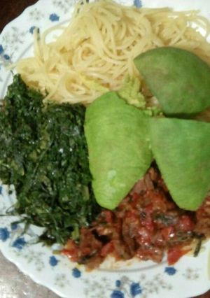 A picture of Spaghetti with meat stew and sukuma wiki.