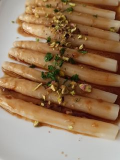 Una foto de Espárragos con vinagreta de naranja y pistachos