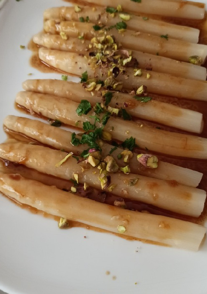 Una foto de Espárragos con vinagreta de naranja y pistachos