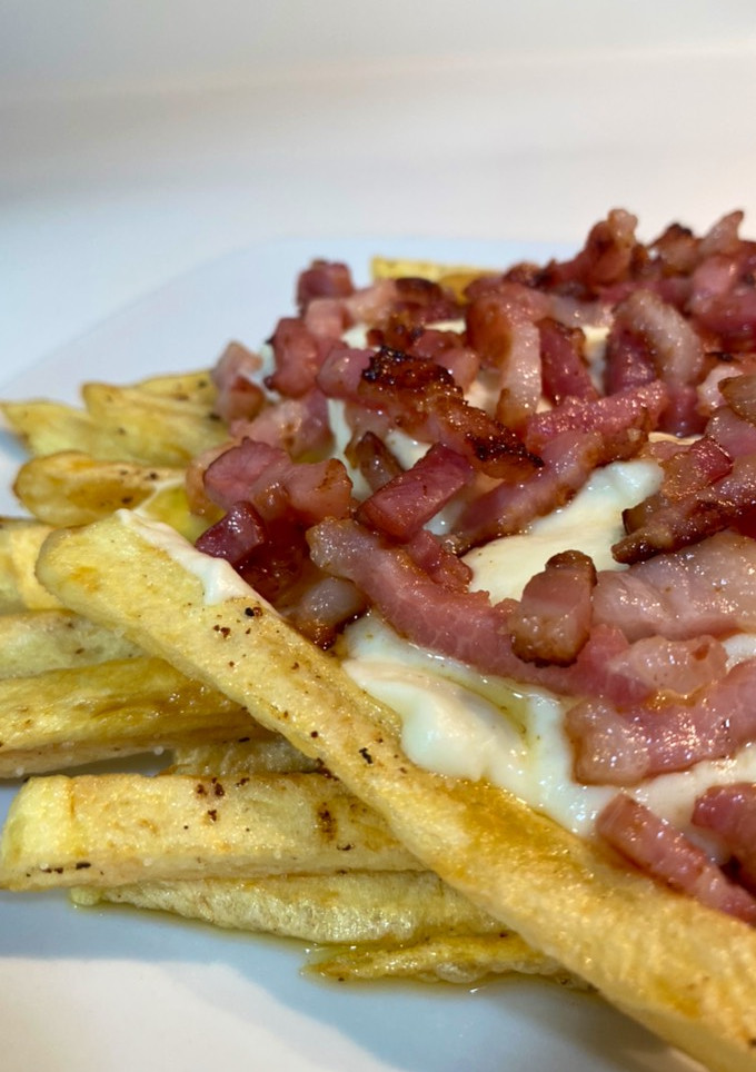 Una foto de Patatas fritas con bacon, nata y queso