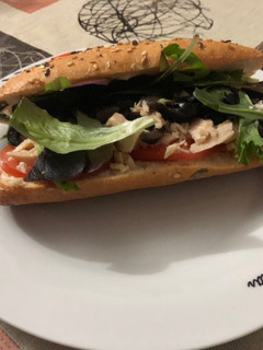 Una foto de Bocadillo de atún con brotes de lechuga variada, tomate, olivas negras y mahonesa