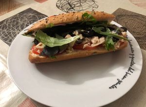 Una foto de Bocadillo de atún con brotes de lechuga variada, tomate, olivas negras y mahonesa