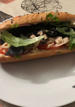 Una foto de Bocadillo de atún con brotes de lechuga variada, tomate, olivas negras y mahonesa