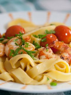 Una foto de Tallarines con tomates cherry y langostinos