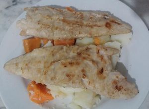 Una foto de Lomitos de Merluza a la plancha, sobre colchón de papas y boniatos