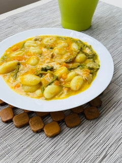 Una foto de Ñoquis con pavo y salsa de curry, calabaza y espárragos