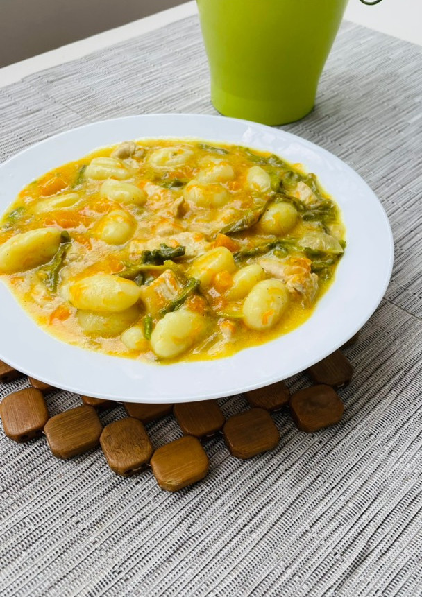 Una foto de Ñoquis con pavo y salsa de curry, calabaza y espárragos
