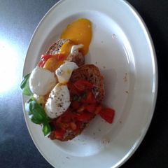 A picture of soft boiled eggs with tomato and basil and halloumi.