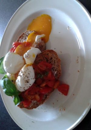 A picture of soft boiled eggs with tomato and basil and halloumi.