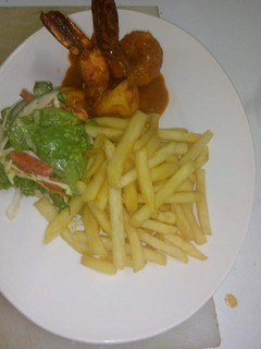 A picture of Jumbo prawns in tomatoes sauce with chips.