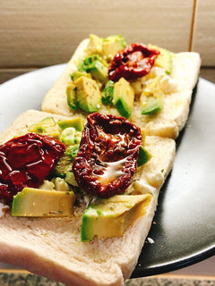 Una foto de Tostada de aguacate, queso feta y tomate seco