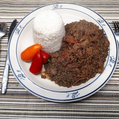 A picture of Lentils and shredded beef served with rice.
