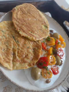 Una foto de Tortitas saladas de Zucchini & Entrante de Tzaziki con aceitunas griegas & tomates cherry 🩵