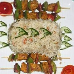 A picture of Egg fried rice with chicken shahlik sticks.