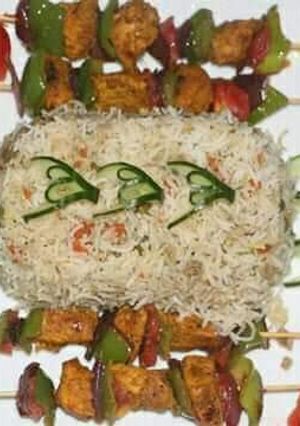 A picture of Egg fried rice with chicken shahlik sticks.
