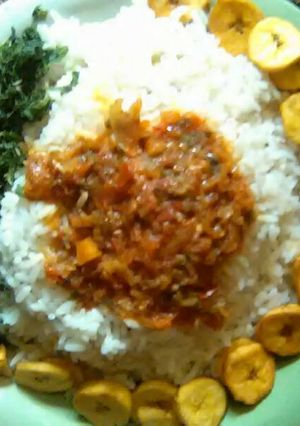 A picture of White rice,tomatoes sauce,plantain and spinach leave.