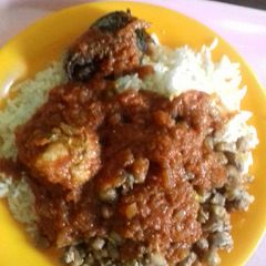 A picture of Rice, beans, stew with chicken and fish.