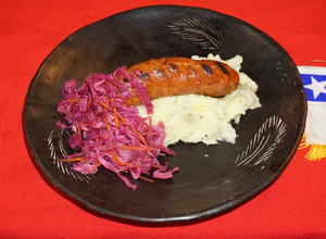 Una foto de Longaniza sureña casera con puré de papas al ajillo y chucrut morado