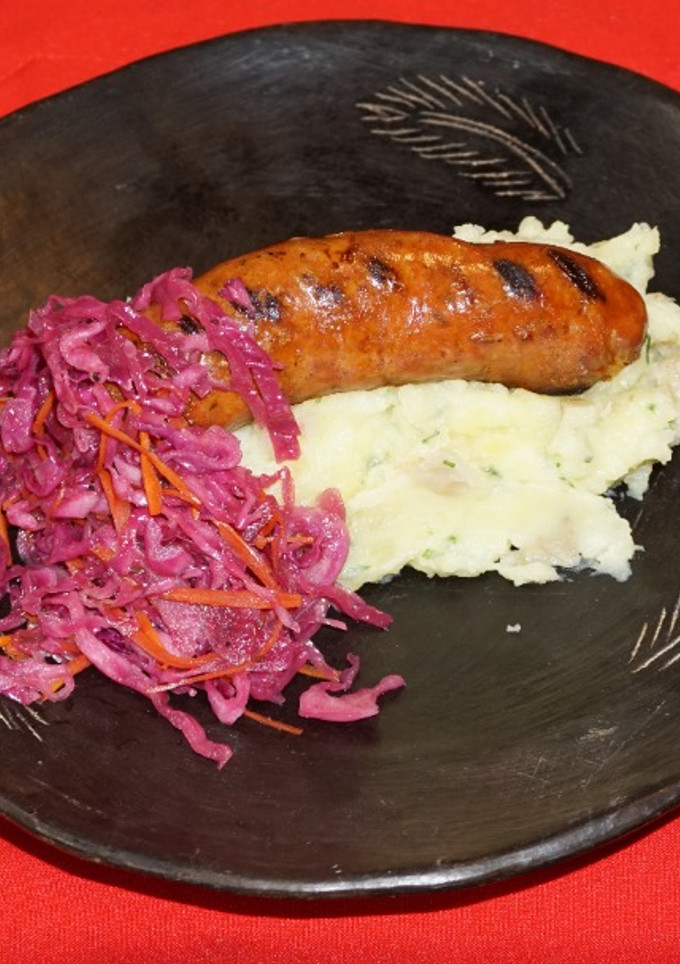Una foto de Longaniza sureña casera con puré de papas al ajillo y chucrut morado