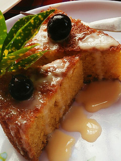 A picture of Maize Malva Pudding drizzled with custard.
