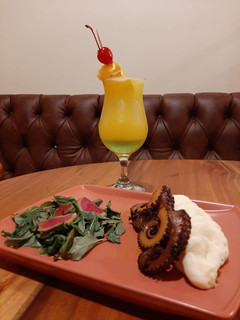 Una foto de Pulpo en salsa de chintextle con puré de papá y ensalada fresca,