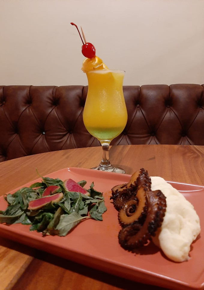 Una foto de Pulpo en salsa de chintextle con puré de papá y ensalada fresca,