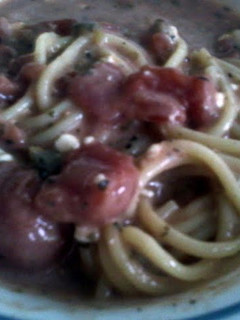 A picture of meatless garlic spaghetti with stewed tomatoes.