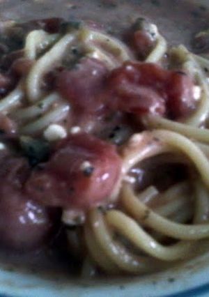 A picture of meatless garlic spaghetti with stewed tomatoes.
